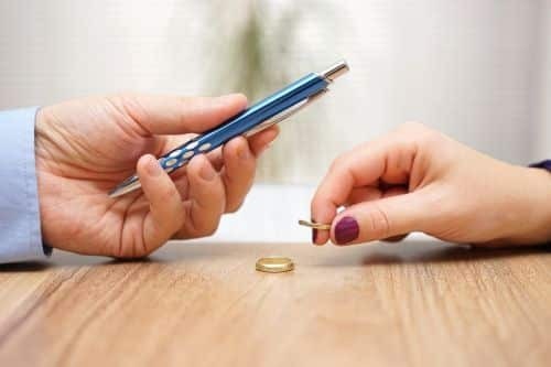 two people setting wedding rings on a table.