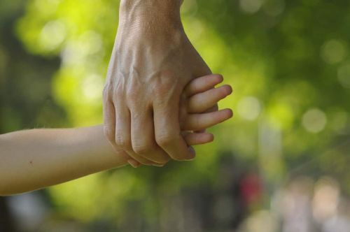 A parent and a child holding hands.
