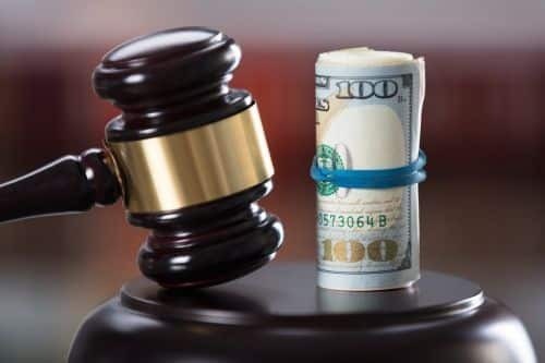 a gavel closeup with a roll of money