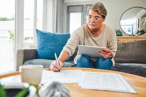 a woman sorting through paperwork on a coffee table